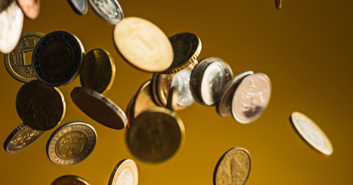 The silver and golden coins and falling coins on wooden table background